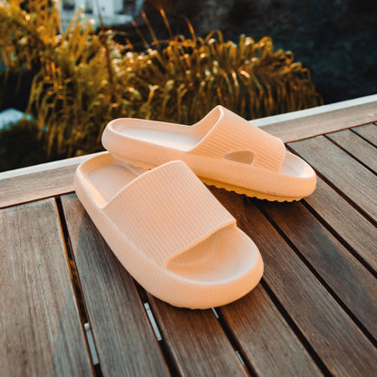 Men's tan slippers on wooden platform